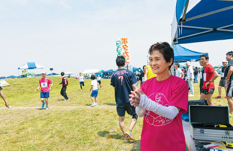 コース際から熱い声援を送る実行委員長の萬田美代子（まんだ みよこ）さんの写真