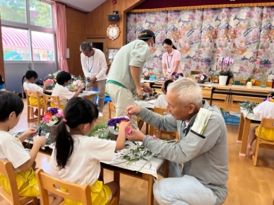 切花生産者が園児と一緒にアレンジメントをする様子