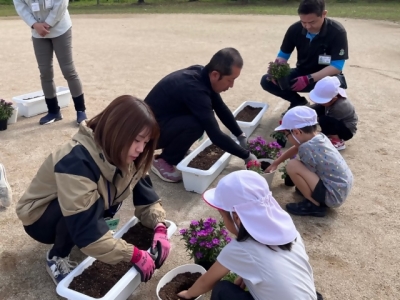 鉢花生産者が園児と一緒に寄せ植えしている様子